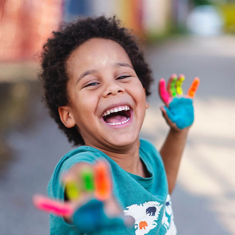 Smiling child with paint on his hands